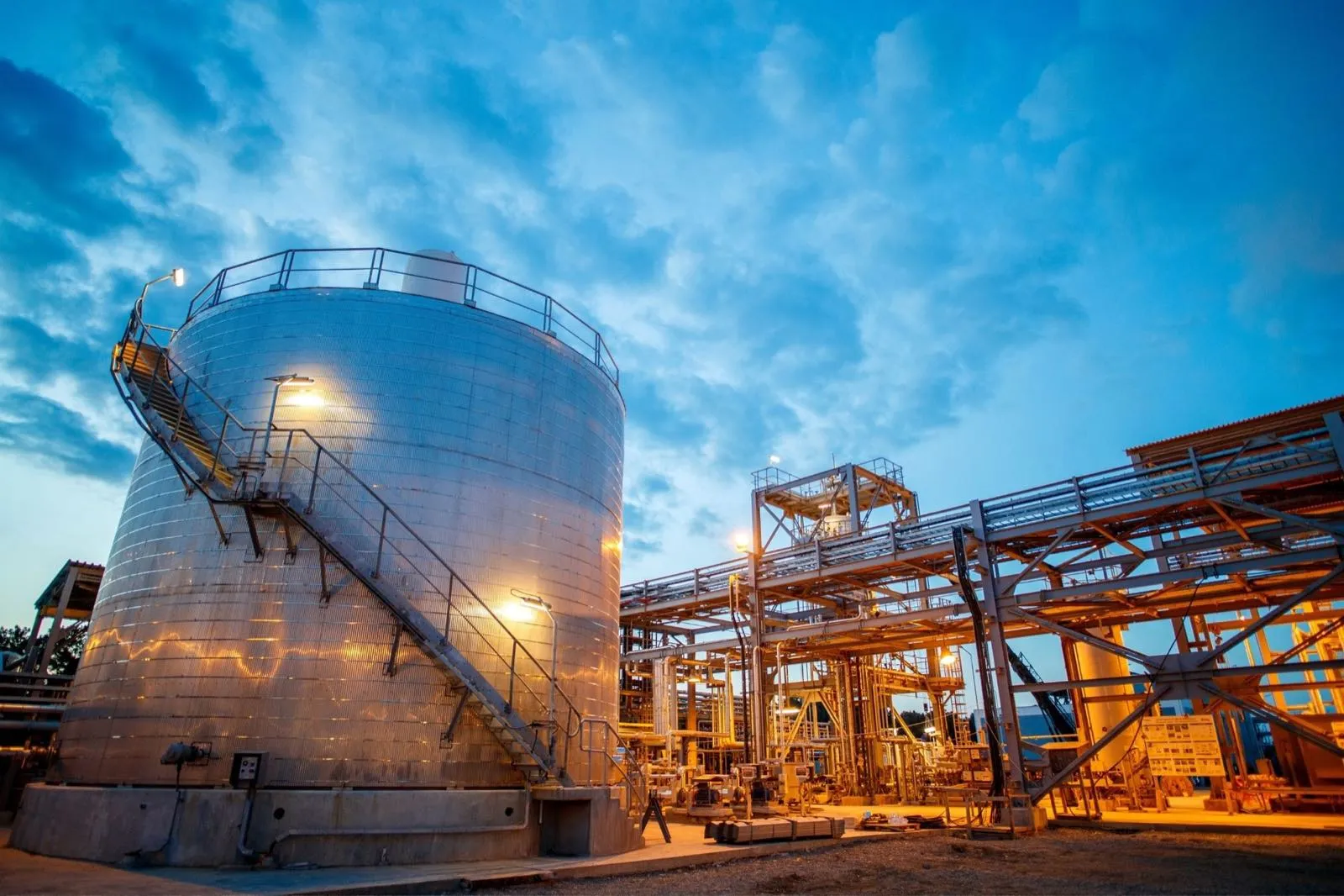 PT Tran Indah Karya storage tanks and pipe installation at dusk